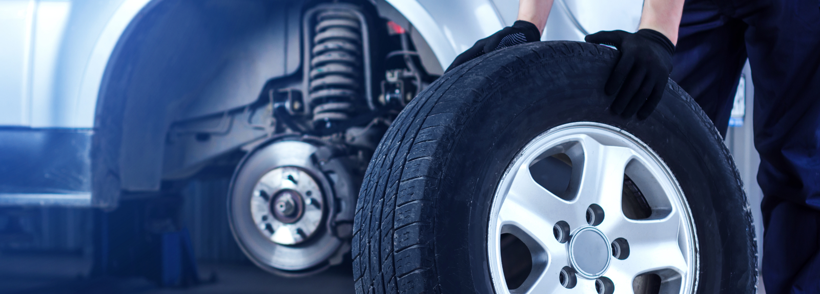 Mechanic pushing a tyre on the floor - Tyres Abernethy, Perth